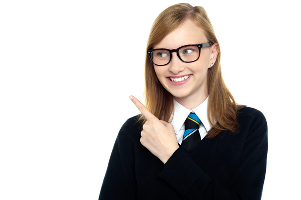 Bespectacled smiling student pointing away - Foto, Imagem