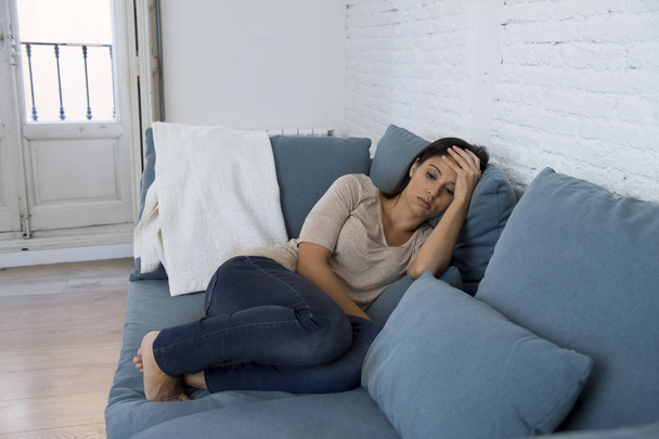 junge attraktive lateinamerikanische Frau liegt zu Hause Couch besorgt leiden Depressionen fühlen sich traurig und verzweifelt - Foto, Bild