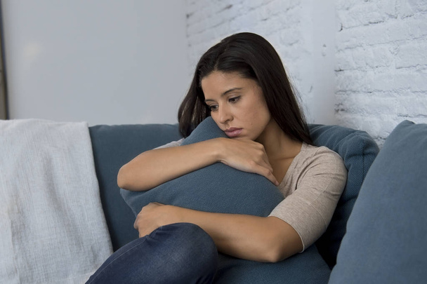 молодая привлекательная латинская женщина лежит дома диван беспокоится страдает депрессией чувство грусти и отчаяния
 - Фото, изображение