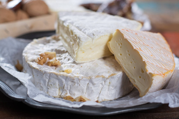Variedad de quesos suaves franceses - camembert, marcaire, munster, brie - delicioso postre con frutos secos y frutos secos
 - Foto, imagen