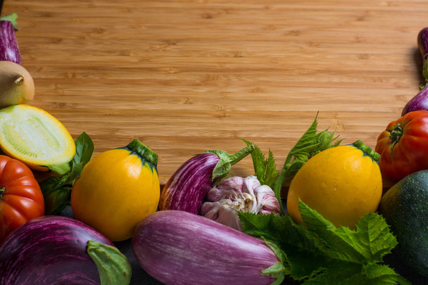Bamboe πλάκα με το διάστημα αντίγραφο, ιδέα εστιατόριο με φρέσκα πολύχρωμα βιολογικά λαχανικά - στρογγυλή μικρές μελιτζάνες, κολοκυθάκια, ντομάτες, δίαιτα έννοια, Ιταλικά και γαλλικά τρόφιμα, υγιεινά τρόφιμα. Μενού temptale. - Φωτογραφία, εικόνα