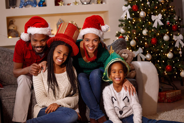 portrait of afro American family in Santa hats on Christmas - Фото, изображение