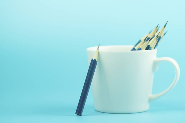 pencils standing alone out of i white cup on blue background - Zdjęcie, obraz