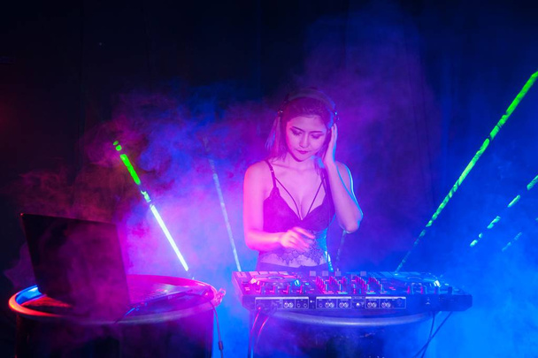 Jolie asiatique femme DJ jouer de la musique pour la danse
. - Photo, image