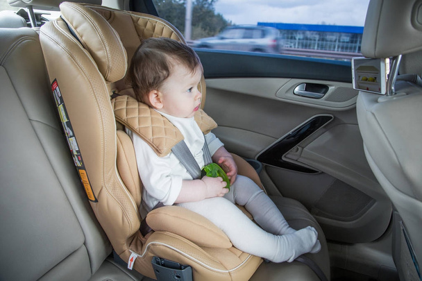 child in a baby car seat. Isofix clamping. beige car seat in a bright salon - Valokuva, kuva