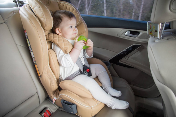 child in a baby car seat. Isofix clamping. beige car seat in a bright salon - Zdjęcie, obraz