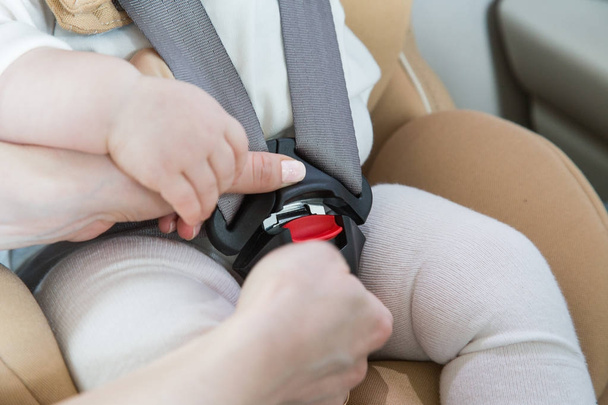 child in a baby car seat. Isofix clamping. beige car seat in a bright salon - Fotoğraf, Görsel