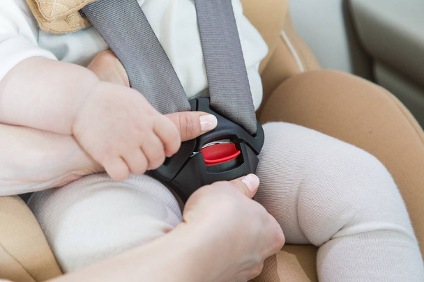 child in a baby car seat. Isofix clamping. beige car seat in a bright salon - Photo, image
