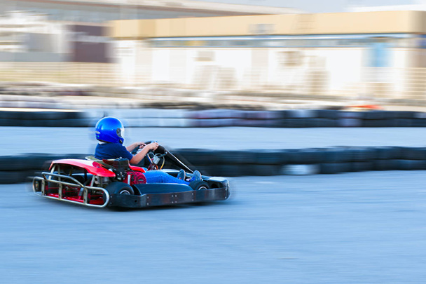 Competition karting - driver in protective form at speed passes a circle of kart trace. - Фото, изображение