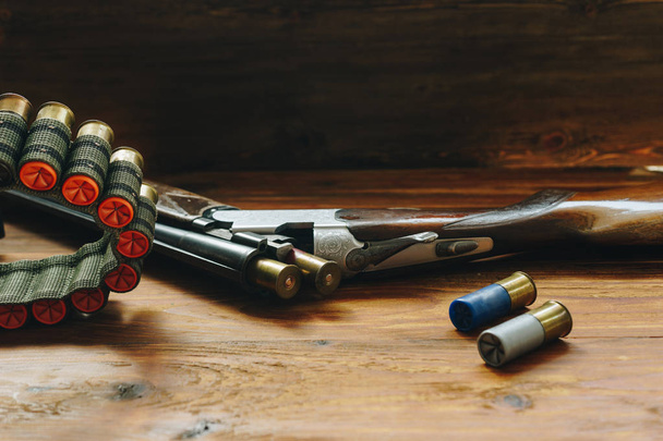 Hunting equipment. Shotgun and hunting cartridges  on wooden tab - Photo, Image