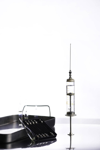Old metal medical syringe and accessories on the table - Photo, Image