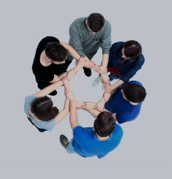 Top view of young people with their hands together in a circle. - Фото, зображення