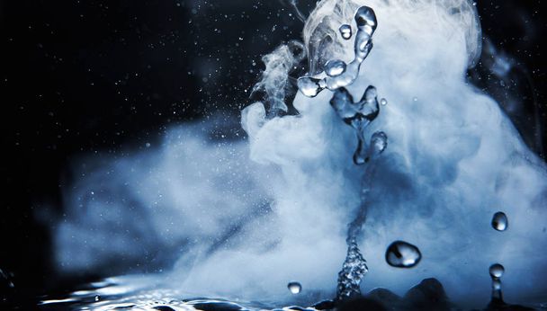 Boiling water splash with steam on black background closeup - Foto, immagini
