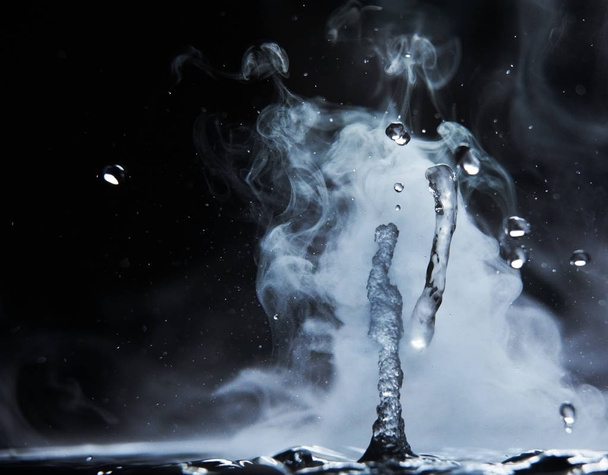 Boiling water splash with steam on black background closeup - Фото, зображення