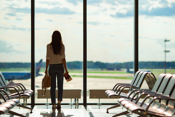 Silueta de pasajera femenina en un salón del aeropuerto esperando aviones de vuelo
 - Foto, Imagen