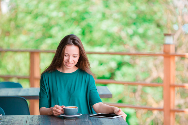 Счастливая городская женщина пьет кофе в кафе
 - Фото, изображение