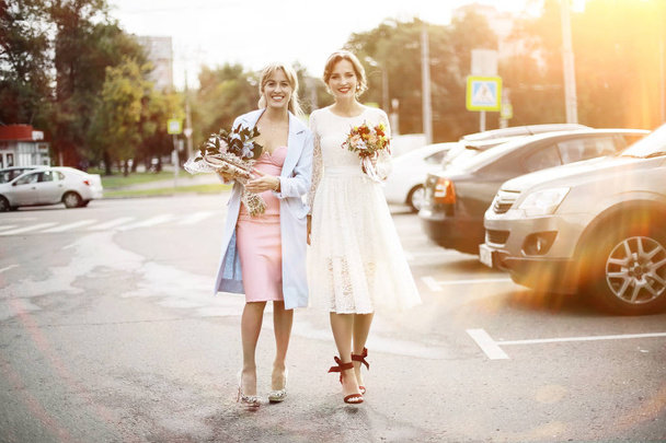 bride in wedding dress and bridesmaid  - Foto, afbeelding