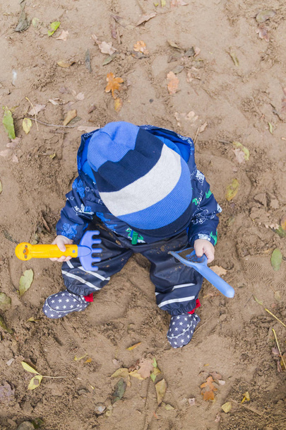 μωρό παίζει στην άμμο το φθινόπωρο - Φωτογραφία, εικόνα
