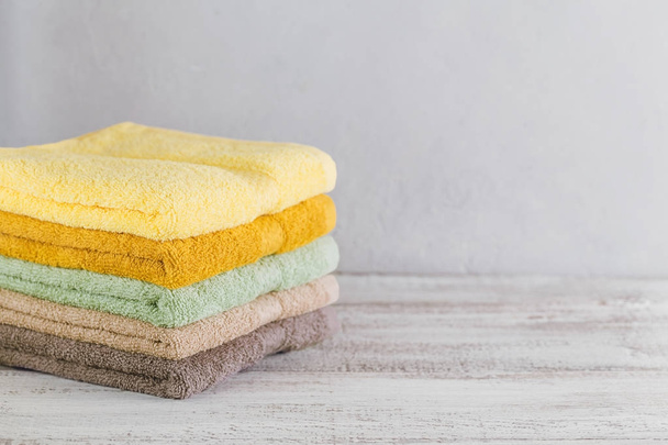 Stack of colorful bath towels on light background.  - Φωτογραφία, εικόνα