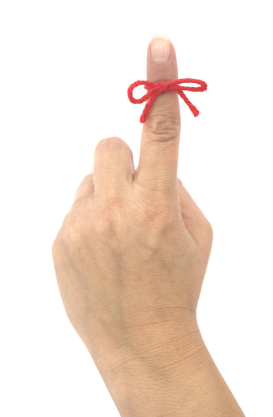 Reminder concept. Isolated hand with a red string bow attached - Photo, Image