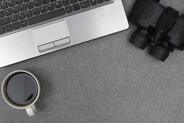 Laptop computer or notebook, binocular and cup of coffee on work - 写真・画像