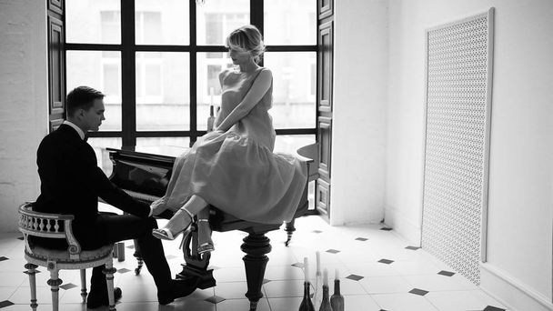 man playing grand piano and woman  - Фото, зображення