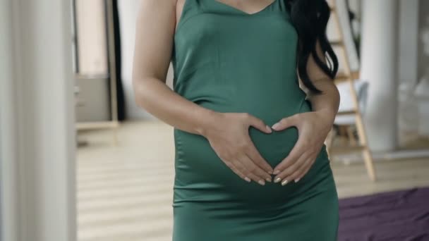 Close-up of womens hands made heart on the stomach, highlighted on a green dress. The concept of health care. - Filmagem, Vídeo