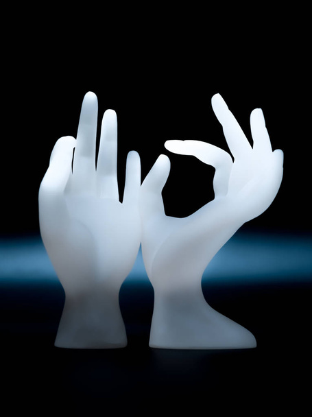 Soporte de exhibición de anillo de resina de forma de mano OK para exhibición de joyería en fondo oscuro uso para diseño publicitario para joyería o salón de uñas
 - Foto, Imagen