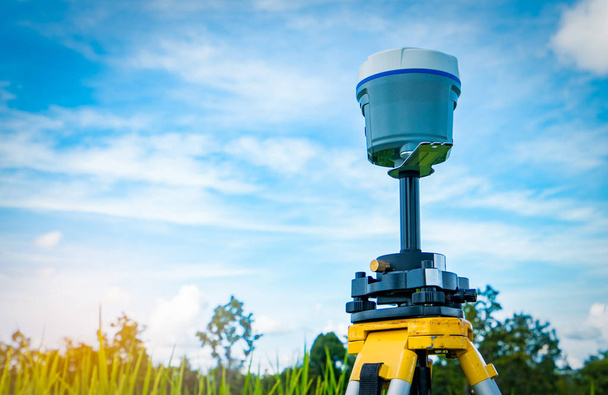 Instrument de levé GPS sur fond bleu ciel et rizière
 - Photo, image