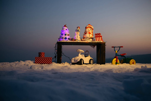 Ευτυχισμένοι χιονάνθρωποι έτοιμοι να γιορτάσουν τα Χριστούγεννα στα βουνά. Οι καλύτερες διακοπές στα βουνά. Διακοπές της Πρωτοχρονιάς στα βουνά. Παιδικά παιχνίδια στο χιόνι. Χωριό το χειμώνα - Φωτογραφία, εικόνα