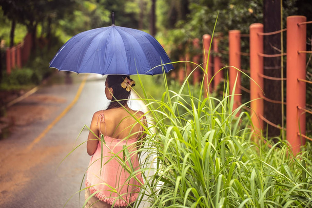 Menina com guarda-chuva na estrada
 - Foto, Imagem