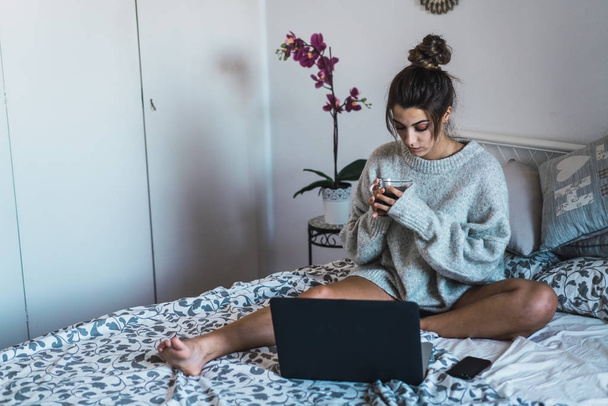 mulher tomando café e usando laptop
  - Foto, Imagem