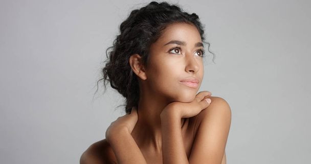 happy serene young woman with beautiful olive skin and curly hair ideal skin and brown eyes in studio - Fotoğraf, Görsel