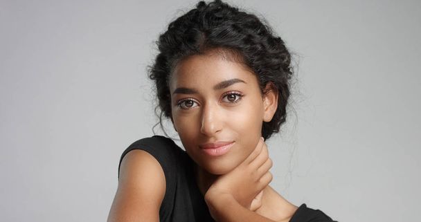 Привлекательная молодая ближневосточная модель трогает свое красивое лицо безупречной кожей
. - Фото, изображение