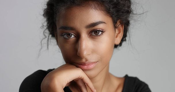 Ελκυστικό νεαρό μοντέλο Μέσης Ανατολής αγγίζοντας το όμορφο πρόσωπό της με αψεγάδιαστη επιδερμίδα. - Φωτογραφία, εικόνα