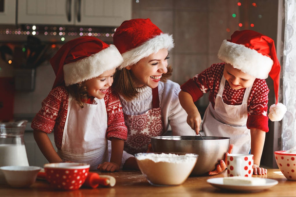 família feliz mãe e crianças assar biscoitos para o Natal
 - Foto, Imagem