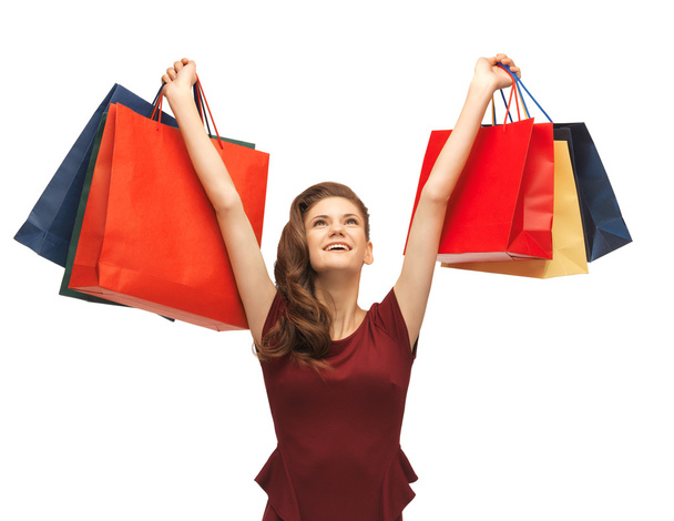 Teenage girl in red dress with shopping bags - Foto, afbeelding