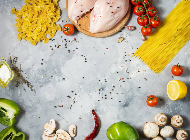 Pasta ingredients. Chicken breasts, Cherry tomatoes, spaghetti pasta and mushrooms on the stone table. Top view with space for text - Fotoğraf, Görsel