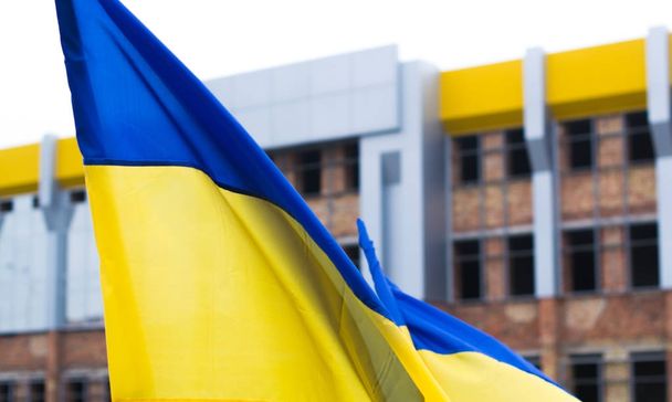 Ukrainian flag on the background of unfinished building. - Valokuva, kuva