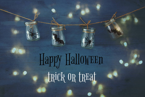 Halloween holiday concept. Masson jars with spiders, baths - Фото, изображение