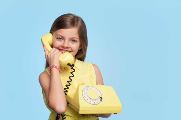 Очаровательная девушка позирует со старым телефоном
 - Фото, изображение