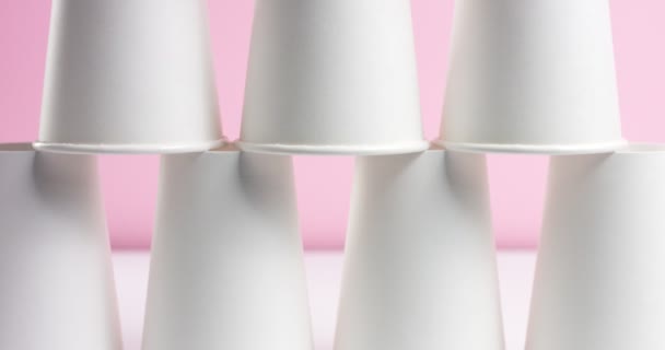 Tour faite de tasses en papier blanc sur fond rose
 - Séquence, vidéo