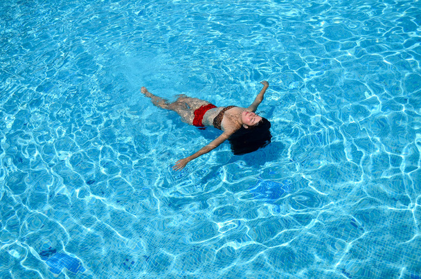 девушка плавает в бассейне - Фото, изображение