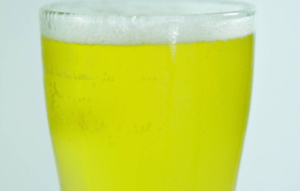  冷たいビールと白い背景上にガラスに泡 - 写真・画像