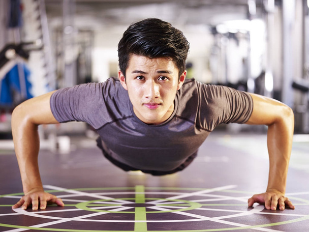 nuori aasialainen mies tekee push-up kuntosalilla
 - Valokuva, kuva