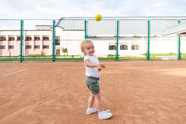 Pequeña linda chica jugando en la cancha de tenis
 - Foto, Imagen