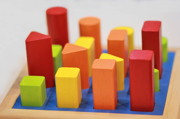 Яркие красочные деревянные детские игрушки сортировщик на полке в магазине
. - Фото, изображение