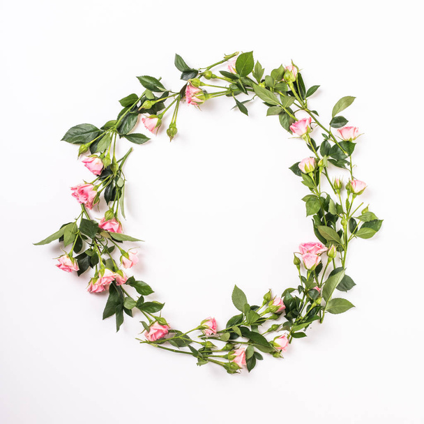 Round frame with pink flower buds, branches and leaves isolated on white background. lay flat, top view - Photo, Image