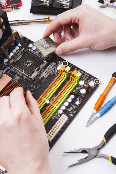 Techniker steckt Mikroprozessor an Motherboard an - Foto, Bild