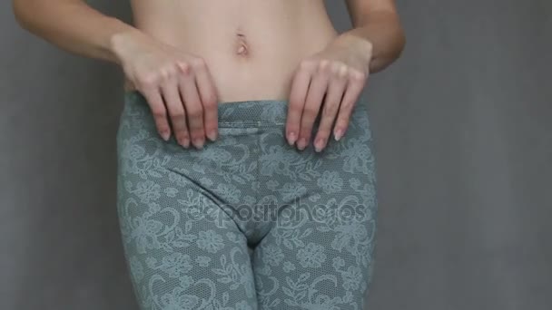 Cute young girl trying to squeeze into tight pants. - Felvétel, videó